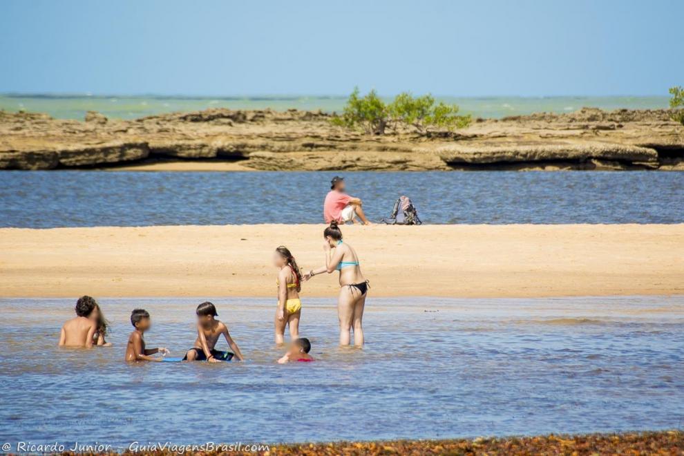 Imagem de crianças aproveitando a piscina natural da Praia de Santo André.